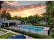 Community pool surrounded by lush trees and a vibrant sunset at 4732 Ashburn Pond Way, Tampa, FL 33610