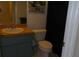 Cozy bathroom featuring a blue vanity with sink, white toilet, and neutral-colored walls, offering a functional space at 4736 Sunny Loop, Holiday, FL 34690
