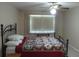 Comfortable bedroom with a patterned bedspread, large window, and ceiling fan at 4736 Sunny Loop, Holiday, FL 34690