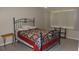 Bedroom with a black metal bed frame, colorful quilt, and neutral carpet, creating a comfortable and inviting space at 4736 Sunny Loop, Holiday, FL 34690
