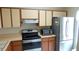 Efficient kitchen layout with stainless steel refrigerator, microwave, and updated oven range at 4736 Sunny Loop, Holiday, FL 34690