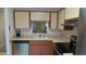Well-lit kitchen area showcasing a stainless steel dishwasher, oven, and light countertops at 4736 Sunny Loop, Holiday, FL 34690