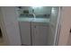 Bright laundry area featuring white side-by-side washer and dryer units, enclosed by louvered doors for added appeal at 4736 Sunny Loop, Holiday, FL 34690