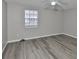This bedroom features wood-look vinyl flooring, a ceiling fan, and a bright window at 4801 W Mcelroy Ave # D104, Tampa, FL 33611