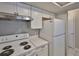 Well-lit kitchen featuring white appliances, cabinets and countertops, alongside a stainless-steel range hood at 4801 W Mcelroy Ave # D104, Tampa, FL 33611