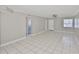 Spacious living room featuring neutral paint, tiled floors, ceiling fan, and ample natural light at 4801 W Mcelroy Ave # D104, Tampa, FL 33611