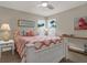 Comfortable bedroom featuring a bright, patterned quilt, ceiling fan, and views from the windows at 500 Westborough Ln, Safety Harbor, FL 34695