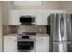 Modern kitchen with stainless steel appliances, including a sleek refrigerator and range, paired with mosaic backsplash at 500 Westborough Ln, Safety Harbor, FL 34695