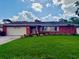 Charming red brick home featuring a lush green lawn, attached garage, and beautiful landscaping at 5201 Denver Ne St, St Petersburg, FL 33703
