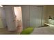 Bedroom with ensuite bathroom featuring wood-look floors and ample natural light at 5318 Mary St, Zephyrhills, FL 33542