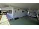 Exterior shot of the carport, featuring the covered parking area, white siding, green trim, and convenient access at 5318 Mary St, Zephyrhills, FL 33542