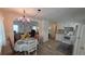 Charming dining room with updated lighting and wood-look floors adjacent to the kitchen at 5318 Mary St, Zephyrhills, FL 33542