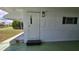 Home entryway with stone steps, green-painted porch and updated exterior lighting at 5318 Mary St, Zephyrhills, FL 33542