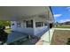 Exterior view of the home, showcasing white siding, green shutters, and a covered carport, adding curb appeal at 5318 Mary St, Zephyrhills, FL 33542