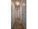 Hallway with wood-look flooring leading to doorways and ample lighting at 5318 Mary St, Zephyrhills, FL 33542
