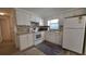 Bright kitchen with white cabinets, appliances, and neutral countertops and backsplash at 5318 Mary St, Zephyrhills, FL 33542