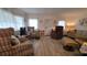 Comfortable living room featuring wood-look flooring and plentiful seating options at 5318 Mary St, Zephyrhills, FL 33542