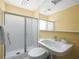 Updated bathroom with a sleek glass-enclosed shower, modern sink, and bright yellow walls at 5409 Pali Way, St Pete Beach, FL 33706