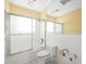 Outdated bathroom featuring a bathtub with sliding doors, tiled walls, and dated fixtures at 5409 Pali Way, St Pete Beach, FL 33706