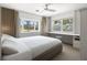 Bright bedroom with built-in desk, bay window, and ceiling fan with outside views at 5409 Pali Way, St Pete Beach, FL 33706