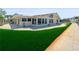 Inviting single-story home featuring a lush green lawn, brick patio, and large windows with a view at 5409 Pali Way, St Pete Beach, FL 33706