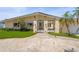 Charming single-story home with well-manicured lawn, concrete driveway, and delightful palm trees, creating a tropical oasis at 5409 Pali Way, St Pete Beach, FL 33706