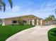 Charming single-story home with well-manicured lawn, concrete driveway, and delightful palm trees, creating a tropical oasis at 5409 Pali Way, St Pete Beach, FL 33706