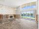 Unfinished living room with fireplace and large windows showcases the potential for waterfront living at 5409 Pali Way, St Pete Beach, FL 33706