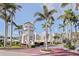 Exterior shot of the community's entrance with a tower and tropical landscaping with palm trees on a sunny day at 6105 Bahia Del Mar Cir # 683, St Petersburg, FL 33715