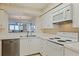 Bright kitchen featuring white appliances, cabinets, and views into the Gathering room and out to the Intracoastal at 6105 Bahia Del Mar Cir # 683, St Petersburg, FL 33715