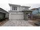 New construction home with stone entryway, white facade, and wide paved driveway and two-car garage at 648 Allora Ave, Nokomis, FL 34275