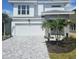 Charming two-story home with a brick driveway, two-car garage, and tropical landscaping at 648 Allora Ave, Nokomis, FL 34275