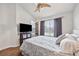 Spacious bedroom featuring a window, ceiling fan, and a large queen-sized bed with wood laminate floors at 6541 Black Mangrove Dr, Largo, FL 33773