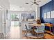 Open dining area with updated kitchen, round wood table, blue accent wall, and sliding door access to the outside at 6541 Black Mangrove Dr, Largo, FL 33773