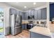 Modern kitchen featuring stainless steel appliances, stylish gray cabinetry, and neutral countertops at 6541 Black Mangrove Dr, Largo, FL 33773