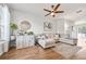 Bright living room featuring a comfortable sectional sofa, stylish decor, and a ceiling fan at 6541 Black Mangrove Dr, Largo, FL 33773