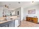 Bright living area with view of the kitchen, featuring wood floors and a decorative wood cabinet at 6541 Black Mangrove Dr, Largo, FL 33773