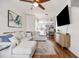 Open-concept living room with hardwood floors, a modern sofa, and a view into the dining area and kitchen at 6541 Black Mangrove Dr, Largo, FL 33773