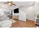 Spacious living room with hardwood floors, television, stairs, and views of the kitchen and dining area at 6541 Black Mangrove Dr, Largo, FL 33773