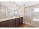 Modern bathroom featuring double sinks, granite countertops, and a glass-enclosed shower at 6937 Gideon Cir, Zephyrhills, FL 33541