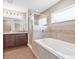 Elegant bathroom features a soaking tub, glass-enclosed shower, and a double vanity at 6937 Gideon Cir, Zephyrhills, FL 33541