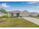 Attractive single-story home features a two-car garage, front yard landscaping, and a well-maintained lawn at 6937 Gideon Cir, Zephyrhills, FL 33541