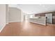 Open-concept kitchen and living area with wood floors, stainless steel appliances, and a granite island at 6937 Gideon Cir, Zephyrhills, FL 33541