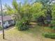 View of the back yard and home with mature trees and utility pole with service lines at 702 W Virginia Ave, Tampa, FL 33603