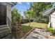 Exterior shot of back side yard with small tree, foliage and a stepping stone patio at 702 W Virginia Ave, Tampa, FL 33603