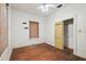 Bedroom with wood floors, a ceiling fan, a small closet with a yellow door and white walls at 702 W Virginia Ave, Tampa, FL 33603