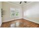 Bedroom has gleaming wood floors, neutral walls, and bright windows at 702 W Virginia Ave, Tampa, FL 33603