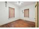 Bedroom with wood floor, ceiling fan, two windows with blinds and a yellow door at 702 W Virginia Ave, Tampa, FL 33603