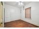 Bedroom featuring wood floors, a ceiling fan, white walls, and a window with tan blinds at 702 W Virginia Ave, Tampa, FL 33603