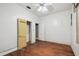 Bedroom with wood floors and white walls has a closet with a yellow door and a window at 702 W Virginia Ave, Tampa, FL 33603